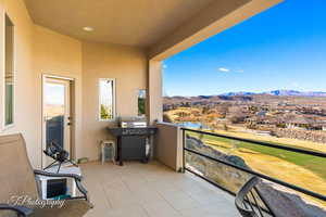 Balcony featuring a water and mountain view and grilling area