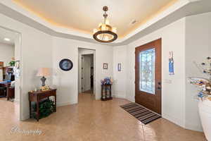 Tiled entrance foyer featuring a tray ceiling