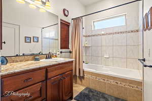 Bathroom featuring vanity and shower / bathtub combination with curtain