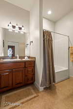 Bathroom with vanity, shower / bath combination with curtain, and tile patterned flooring