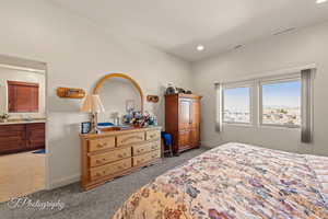 Carpeted bedroom with sink and ensuite bath