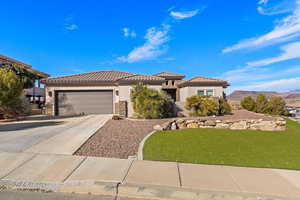 View of front facade with a mountain view, a garage, and a front lawn