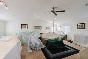 Bedroom featuring light carpet, a wall mounted AC, vaulted ceiling, and ceiling fan