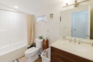 Full bathroom featuring tile patterned floors, shower / bathtub combination with curtain, toilet, and vanity