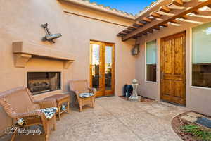 View of patio with exterior fireplace and french doors