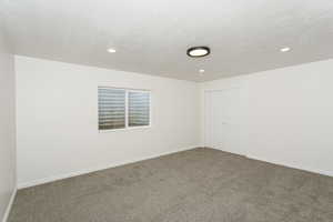 Carpeted spare room featuring a textured ceiling