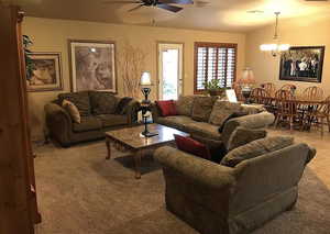 Living room with ceiling fan with notable chandelier