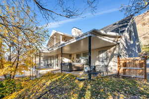 Rear view of property featuring a hot tub