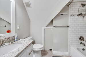 Full bathroom with vanity, toilet, and tiled shower / bath combo