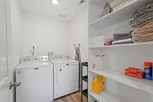 Washroom featuring washer and clothes dryer and light hardwood / wood-style flooring