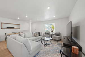 Living room with light hardwood / wood-style floors and a textured ceiling