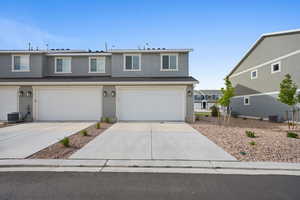 View of property with a garage and central air condition unit