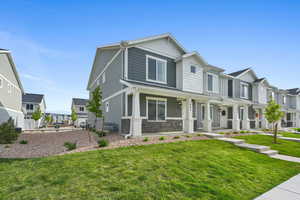 View of front of property featuring covered porch and a front yard