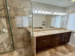 Bathroom featuring vanity and a tile shower