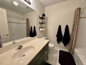 Full bathroom featuring toilet, shower / tub combo, tile patterned floors, and vanity