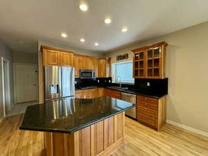 Kitchen featuring a kitchen island, sink, tasteful backsplash, and appliances with stainless steel finishes