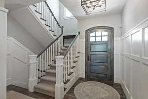 Entryway with dark hardwood / wood-style flooring and an inviting chandelier