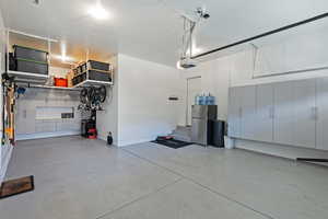 Garage with a garage door opener and stainless steel fridge