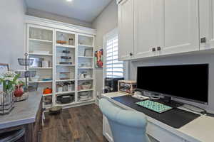 Office with dark hardwood / wood-style flooring