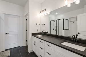 Bathroom with vanity, tile patterned floors, and a shower with door