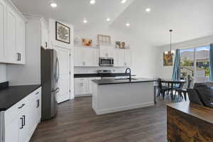 Kitchen featuring hanging light fixtures, white cabinets, sink, stainless steel appliances, and dark hardwood / wood-style floors