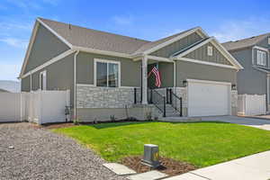 View of front of property with a garage and a front lawn