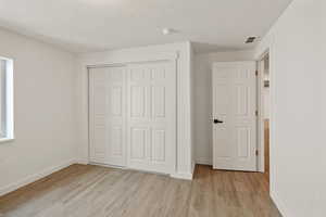 Unfurnished bedroom featuring light hardwood / wood-style floors and a closet