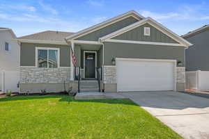 Craftsman-style house with a garage and a front lawn