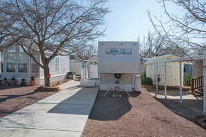 Rear view of house with a storage unit