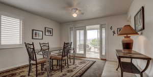 Dining room with ceiling fan, light tile patterned floors, and a textured ceiling