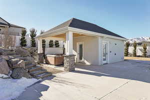 Rear view of property with a patio area and a hot tub