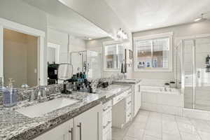 Bathroom featuring vanity, shower with separate bathtub, and a textured ceiling