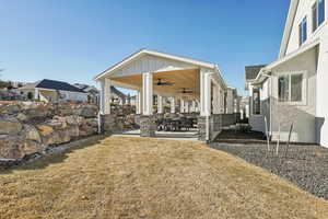 View of yard featuring ceiling fan and a patio