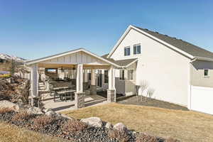 Rear view of house with a patio area and a yard