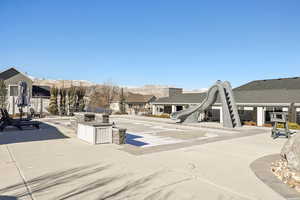 View of home's community with a mountain view, a patio area, and area for grilling