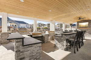 View of patio / terrace with ceiling fan, area for grilling, grilling area, and an outdoor wet bar