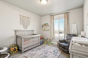 Bedroom with carpet and a crib