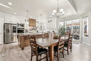 Dining space featuring a textured ceiling, light hardwood / wood-style flooring, and a chandelier