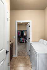 Laundry room with light carpet and independent washer and dryer