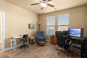 Office area with hardwood / wood-style flooring and ceiling fan