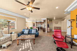 Living room with crown molding and ceiling fan