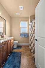 Bathroom with vanity, toilet, and tile patterned flooring