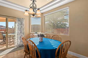 Dining space featuring light tile patterned flooring and a chandelier