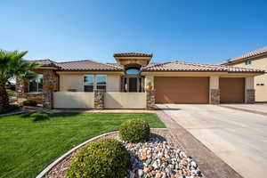 View of front of home with a garage and a front lawn