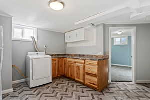 Washroom with washer / dryer, ornamental molding, plenty of natural light, and a textured ceiling