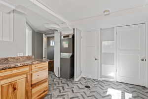 Kitchen featuring heating unit and light brown cabinetry