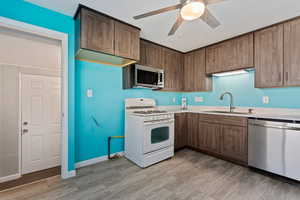 Kitchen featuring ceiling fan, sink, a textured ceiling, and appliances with stainless steel finishes