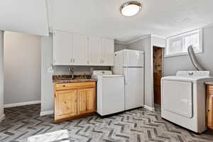 Laundry room featuring cabinets, sink, and crown molding