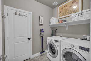 Washroom with independent washer and dryer and light tile patterned flooring