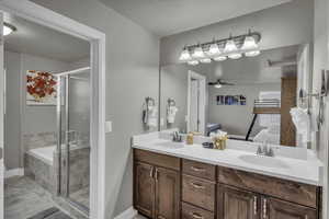 Bathroom with independent shower and bath, ceiling fan, and vanity